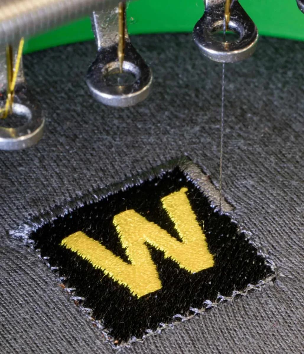 Industrial embroidery machine stitching company logo onto workwear — embroidery Richmond